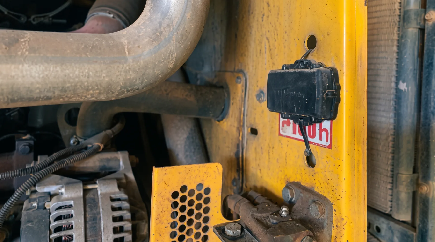 An industrial IoT condition-monitoring sensor mounted on heavy plant machinery, continuously capturing asset-health data