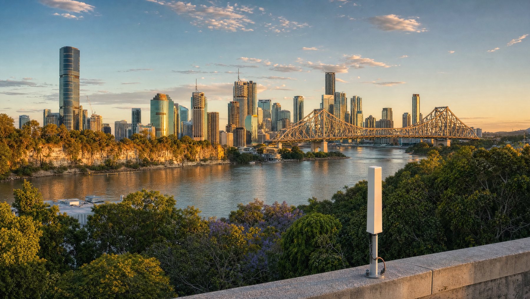 A rooftop antenna overlooking the Brisbane River bend and city skyline at golden hour