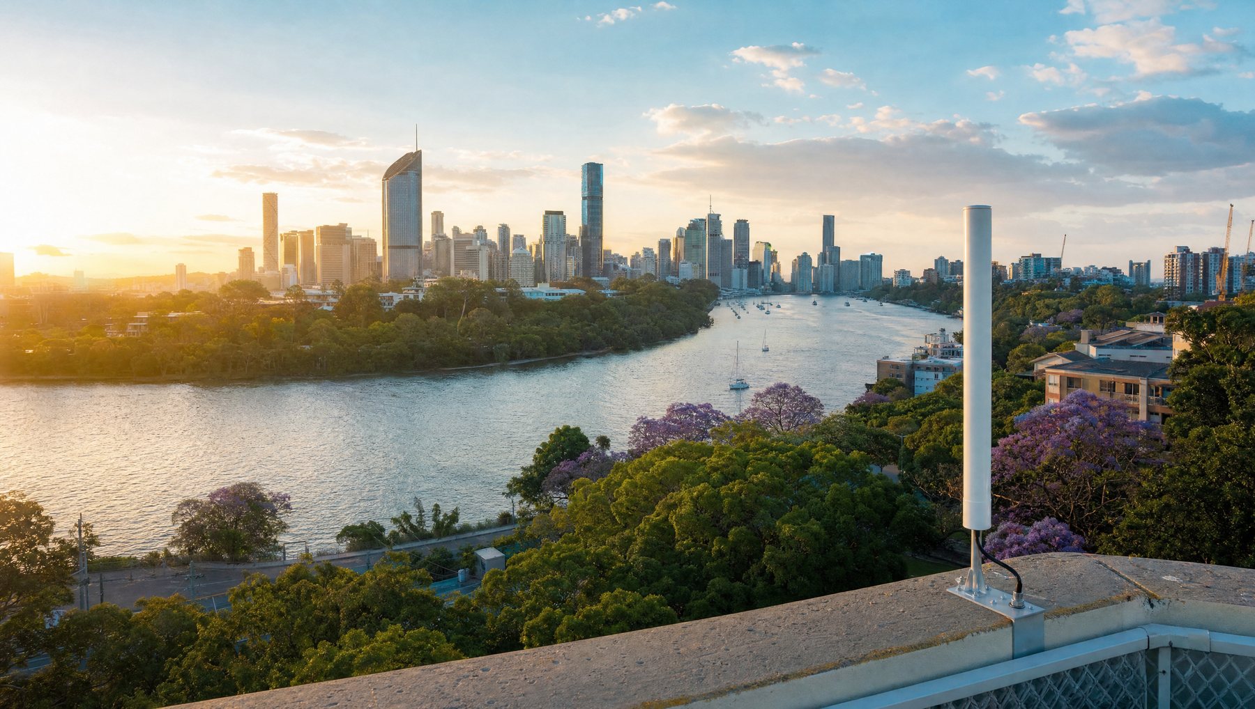 A rooftop antenna overlooking a subtropical river city at golden hour