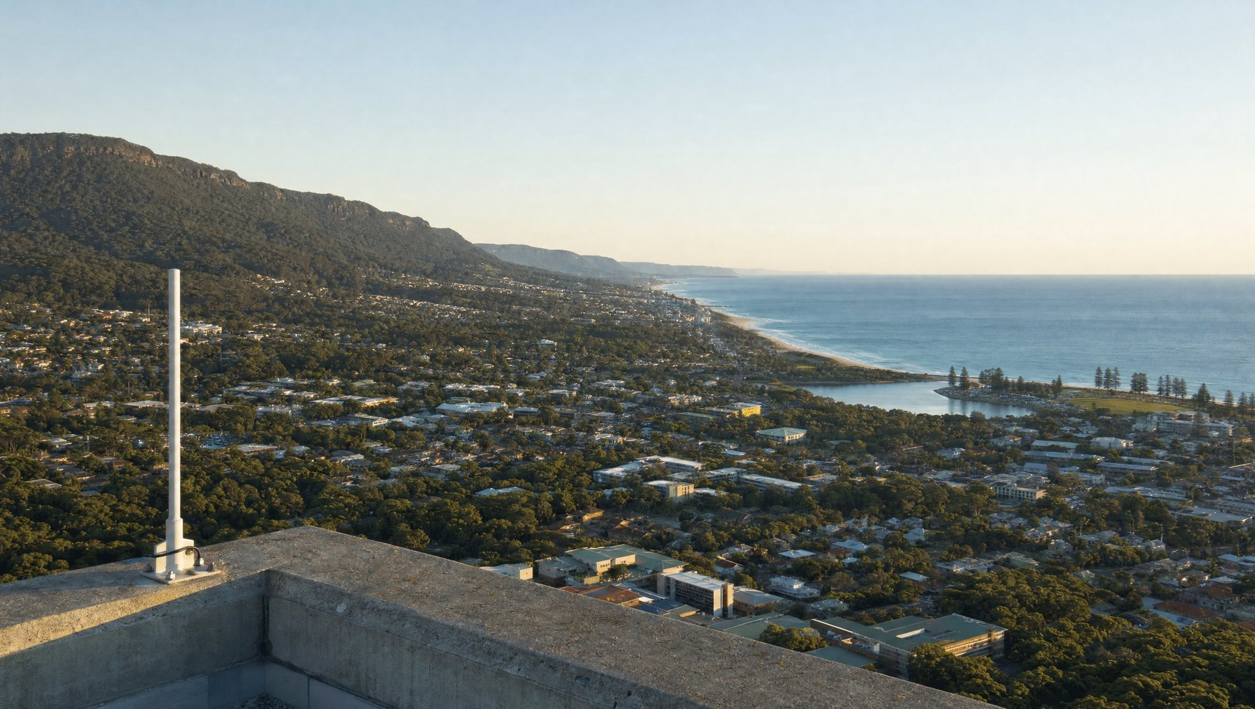 A rooftop antenna above Wollongong, with the escarpment on one side and the Pacific on the other