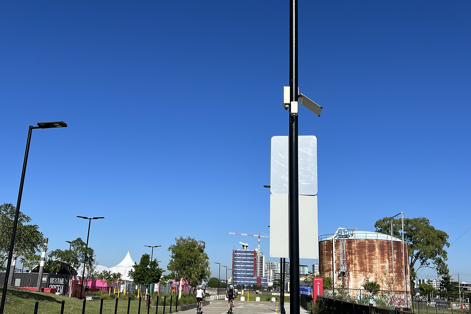 An nCounter device and a slim solar panel mounted partway up a light pole beside a shared pedestrian and cycling path in the precinct