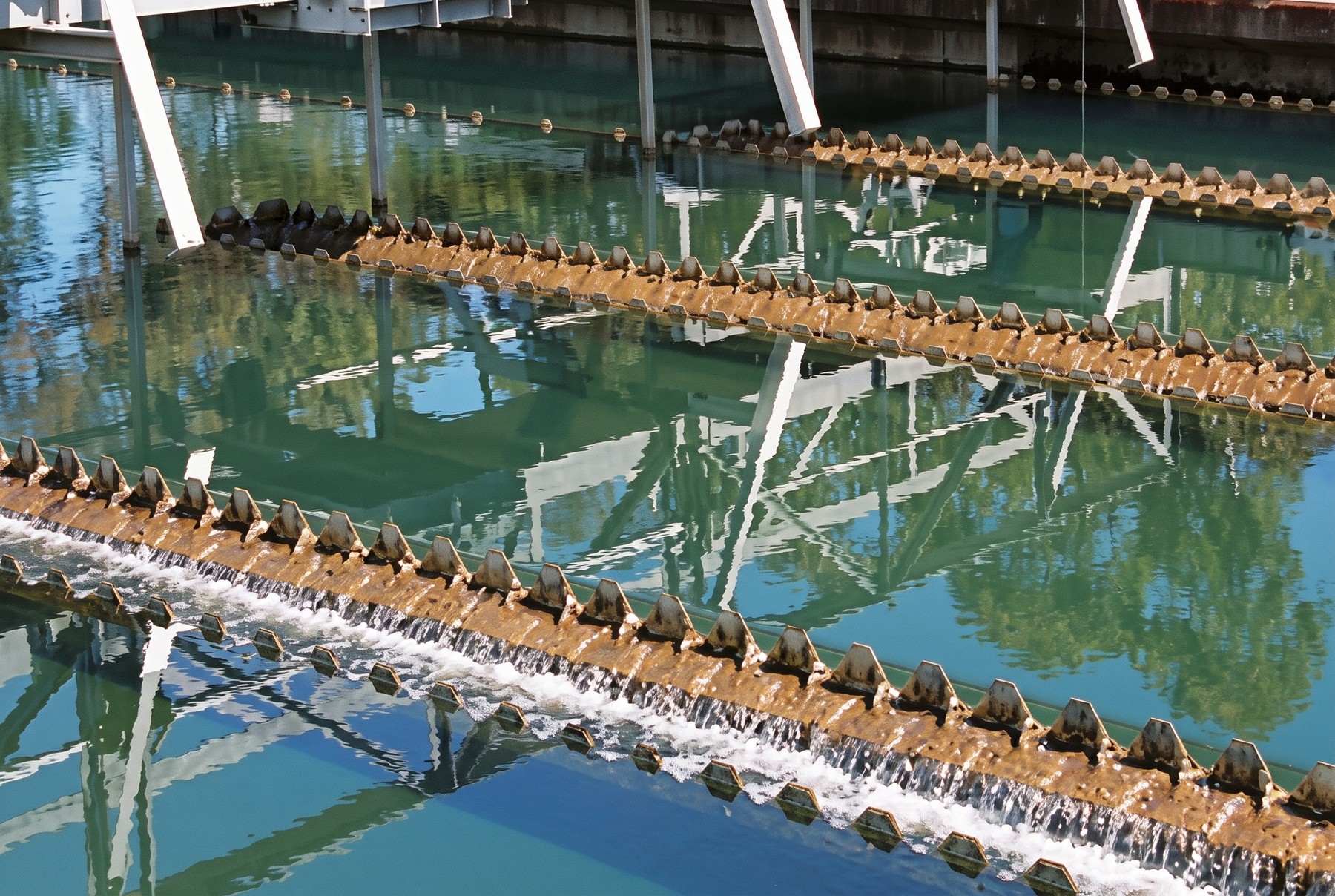 Sedimentation and clarifier tanks at a water treatment plant, steel walkways spanning the basins